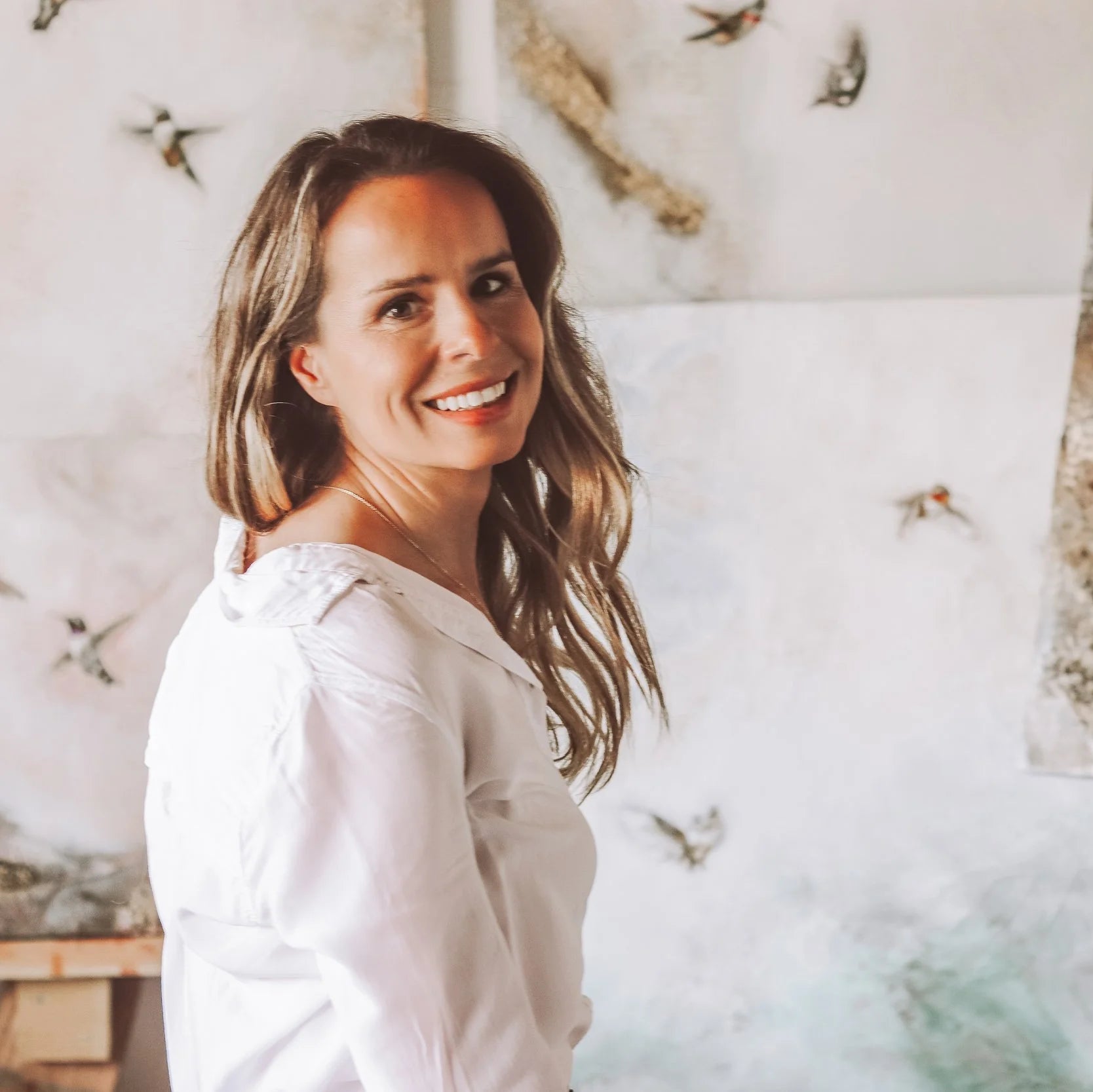 Hummingbird Artist Anja Prescher in front of her hummingbird paintings